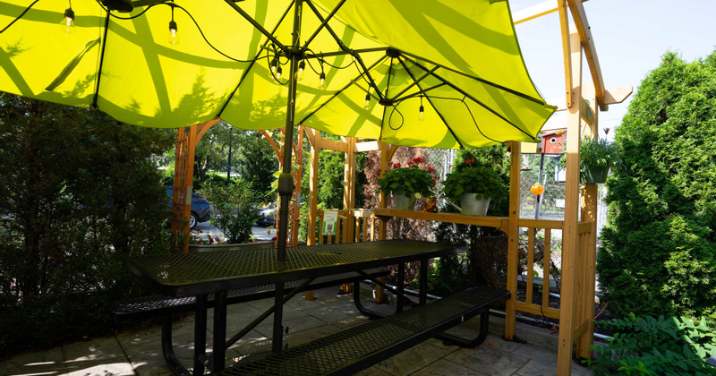 Outdoor seating area, one big table and green sun umbrella
