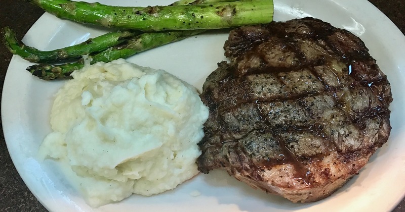 Rib eye steak, asparagus and mashed potatoes on a plate