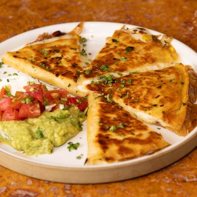 Quesadillas with sour cream, guacamole, and tomato salsa.