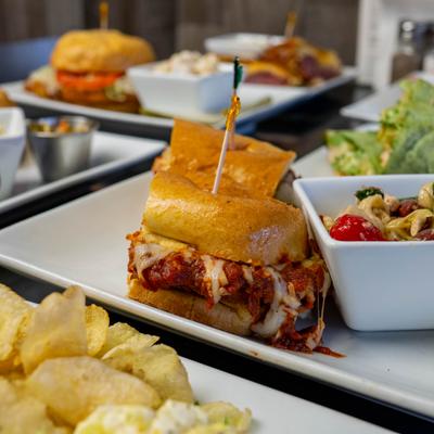 Chicken Parmesan sandwich served with other dishes on the table.