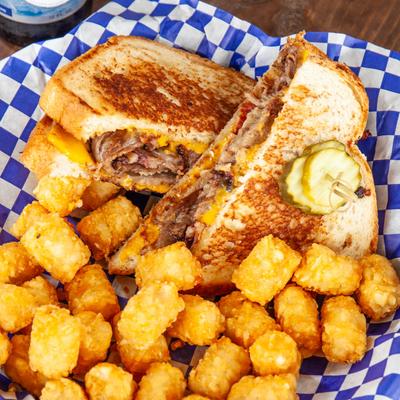 Grilled brisket and cheese sandwich, served with tater tots.