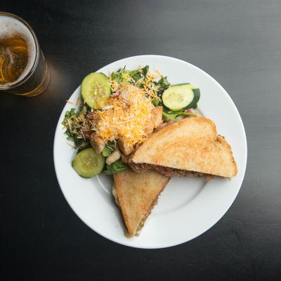 Meadow Melt sandwich served with House salad on the side and a beer.