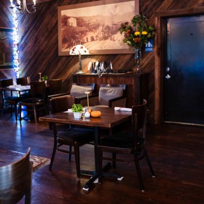 Interior with wood-paneled walls, wooden furniture and framed art.