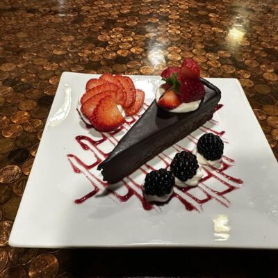Chocolate cake served with fresh strawberries and blackberries.