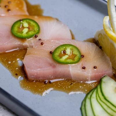 Chili Yellowtail Sashimi topped with thin slices of jalapeño, served with sliced cuccumber.