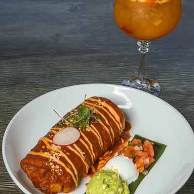 Burrito smothered in red sauce, served with guacamole, sour cream, and salsa.