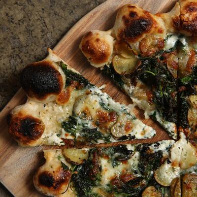 Closeup of organic pizza slices on serving board at Gather in Berkeley restaurant.