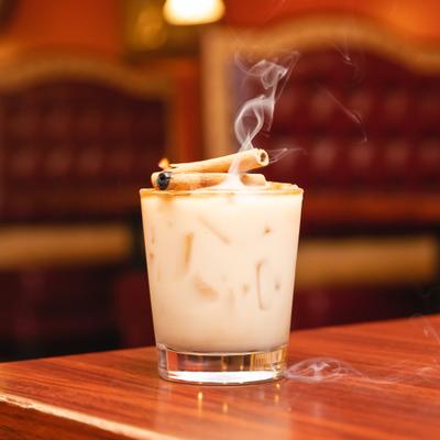 Rumchata cocktail garnished with burnt cinamon stick.