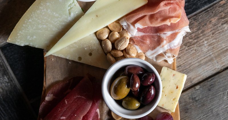 Cheese, meats and olives served on chopping board