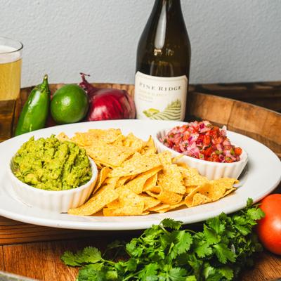 Twisted sister platter, a bottle of wine, fresh vegetables, and a beer.