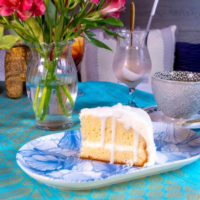 Coconut Ice Cake served alongside clear glass vase holding pink flowers.