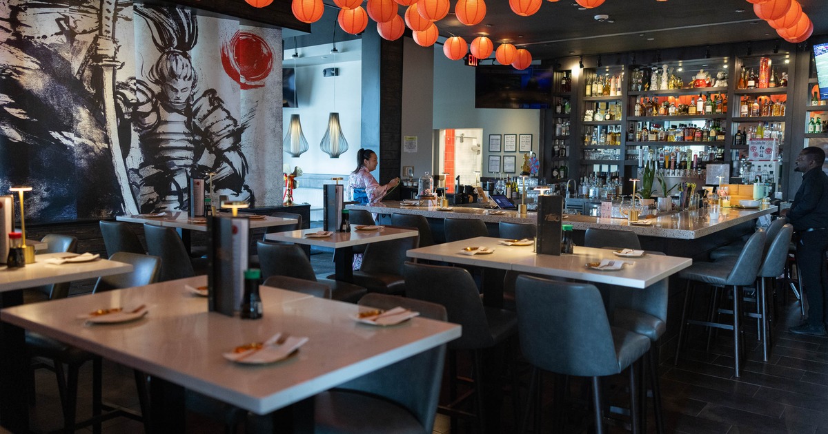 A stylish, modern bar with high tables and gray chairs