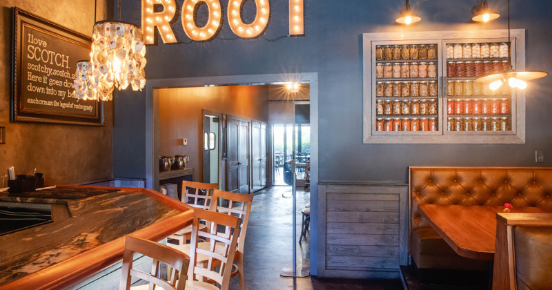 Interior, area by the bar with Root sign on the wall and shelves with jars