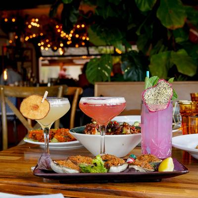 Different cocktails and food dishes served on the table, side view