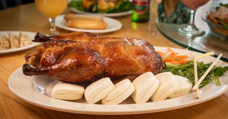 Peking duck with steamed buns and vegetables on the side