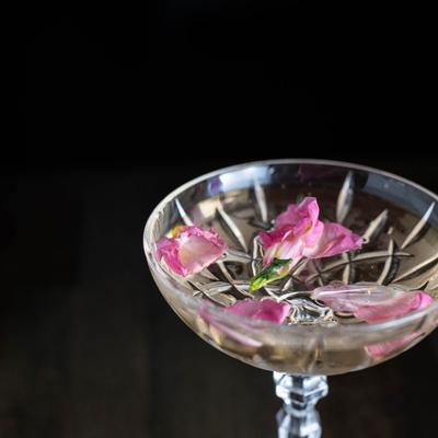 House cocktail with flower leaves in glass