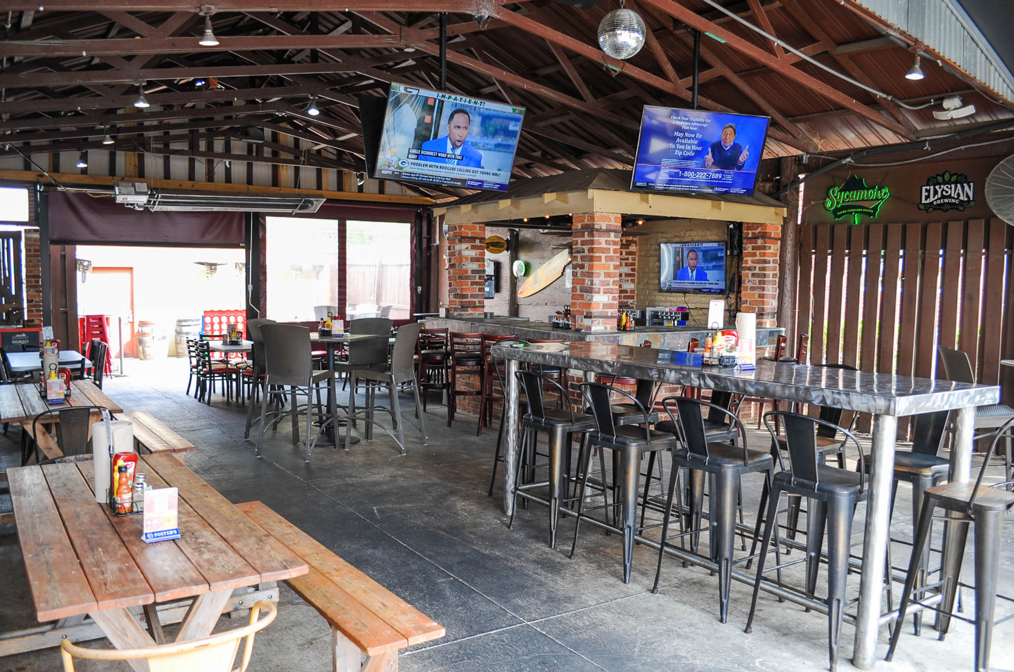 Outdoor bar, seating are with TVs