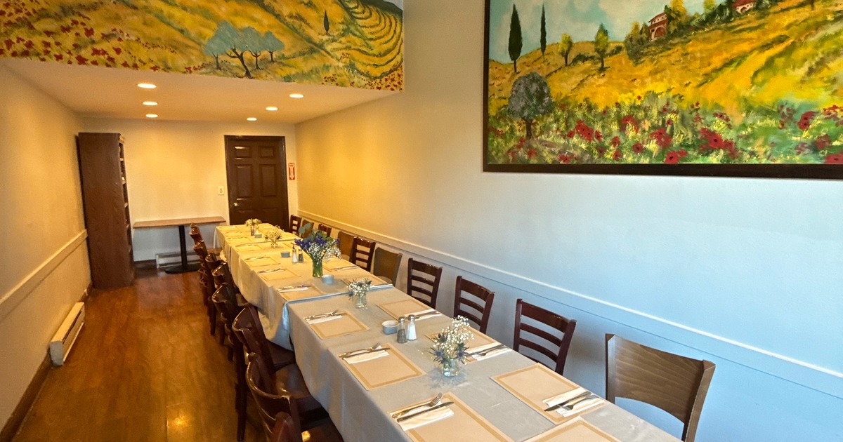 Dining room featuring a long table set for group dining and framed art