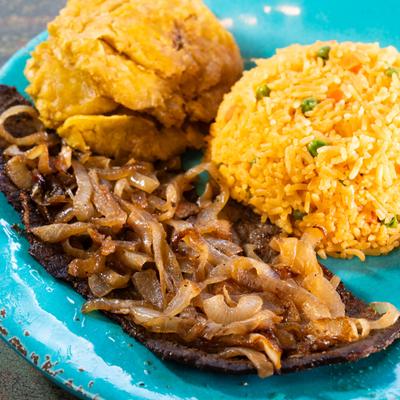Cuban steak and onions served with rice and crispy plantains.