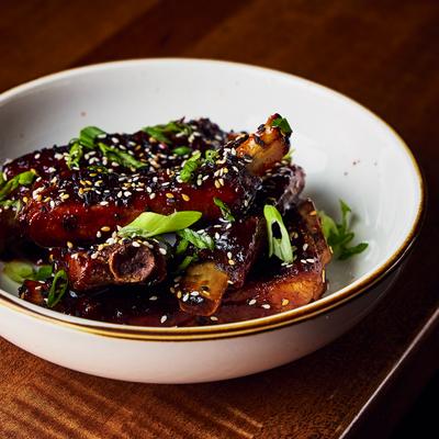 Kalbi marinated ribs in Gochujang sauce with sesame seeds and green onion.