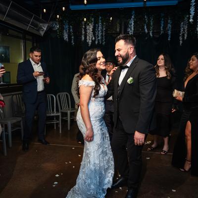 A wedding couple standing next to each other and smiling during a wedding party