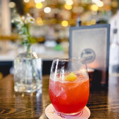 Glass of red cocktail on table