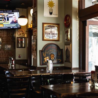 Interior with wooden tables, vintage signs, and a wall-mounted TV.