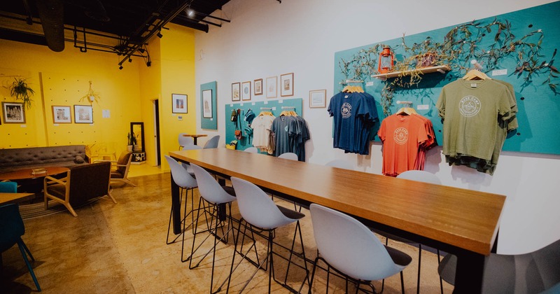Interior, seating area, high community table for ten, merch hanging on the decorated walls