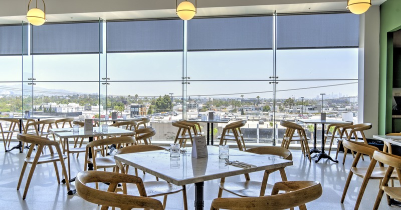 A bright and cozy dining area with large windows and set dining tables