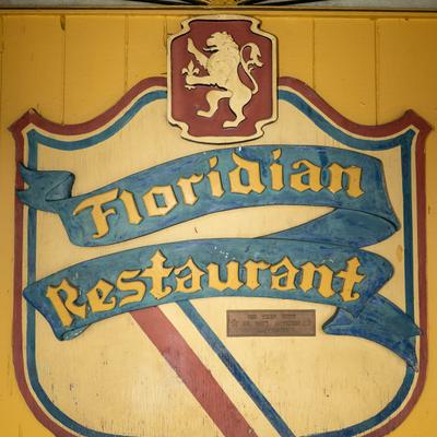 Vintage business sign with the restaurant's name and a lion crest.
