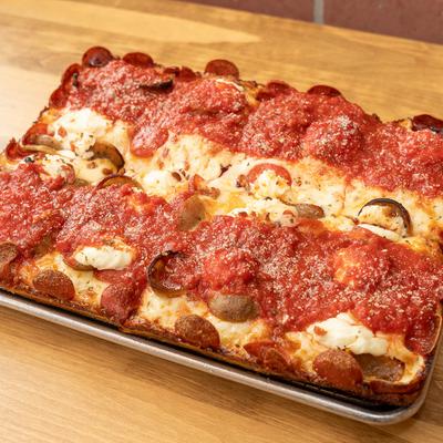 Square deep-dish pepperoni pizza with thick tomato sauce.