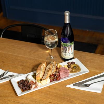 Charcuterie board, bottle of wine, and glass on the side.