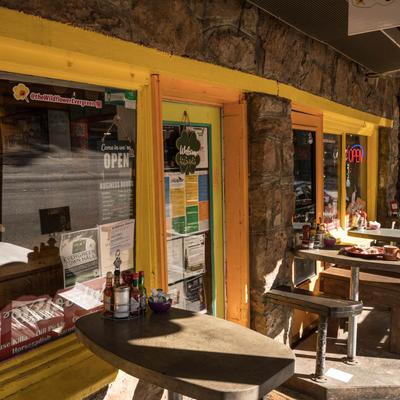 The entrance to the restaurant, tables and chairs in front.