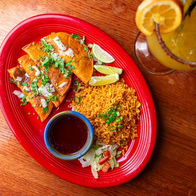 Queabirria tacos served with birria broth and rice.