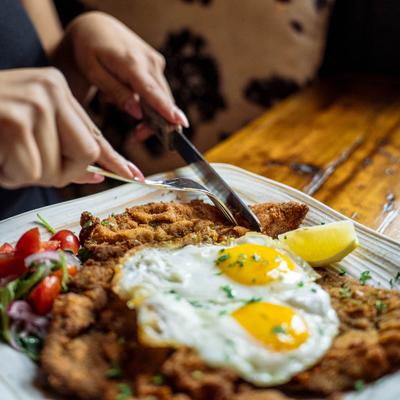 Fried chicken breast topped with sunny side up eggs.
