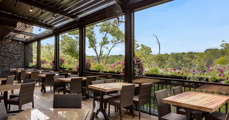 Patio, tables and chairs near windows with flowers