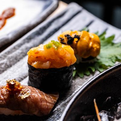 Close-up of sea urchin and seared beef nigiri.