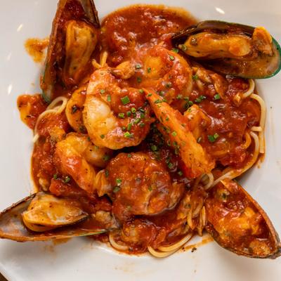 Seafood  with spicy tomato sauce over spaghetti.