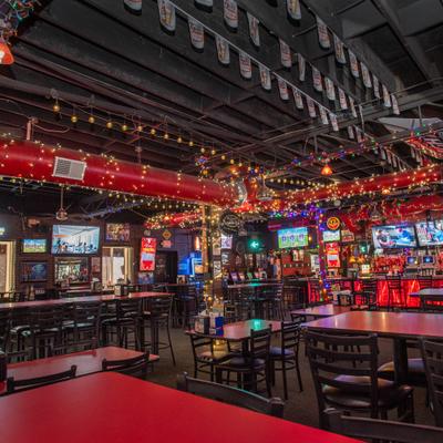 Interior with various seating options, TV screens and string lights.