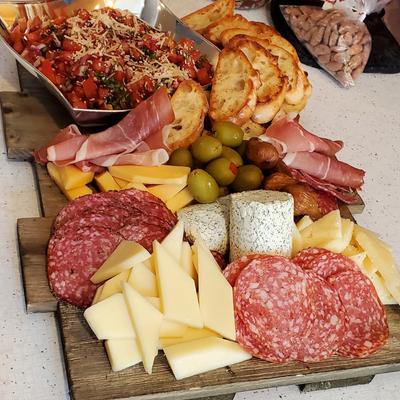 Charcuterie board with assorted cured meats, cheeses, olives, toasted bread.