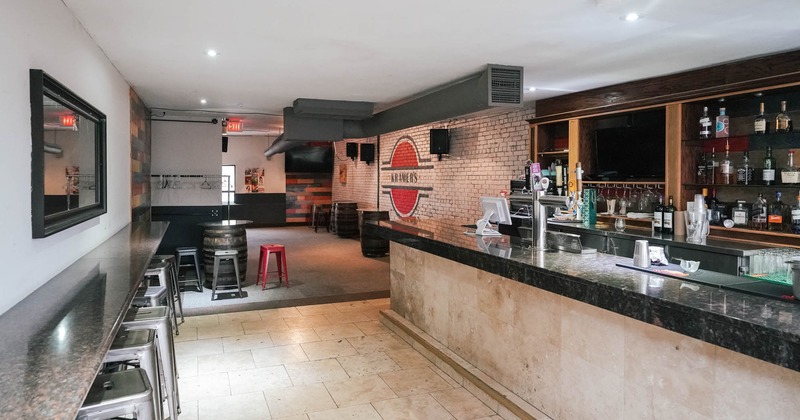 Seating area, barrel tables with bar stools and a bar to the right