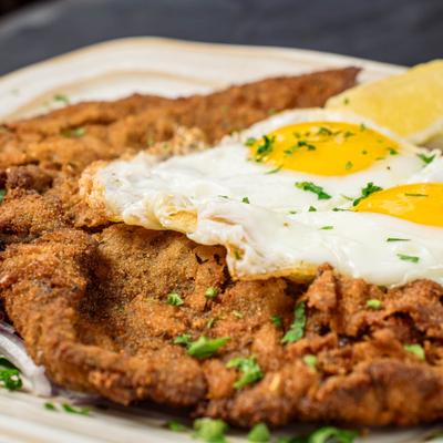 Breaded chicken breast topped with eggs.