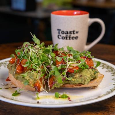 Avocado Smash toast served with a hot beverage in a branded mug.