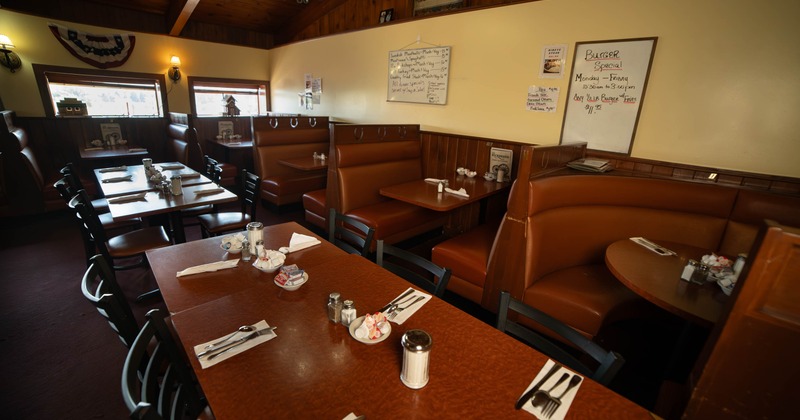 Interior, wooden furniture, brown leather booth seating, and menu boards on the walls