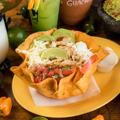 Iceberg lettuce, pico de gallo, beans, cheese, sour cream and avocado, in a tortilla shell