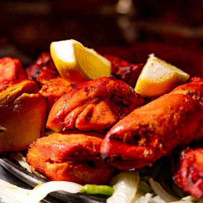 Variety of Indian tandoori dishes served on a hot sizzling platte, close-up.