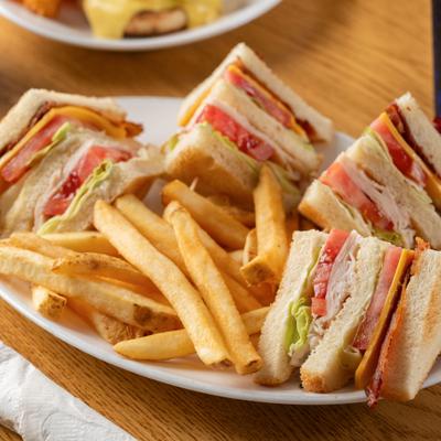 Turkey Club Sandwich served with fries.