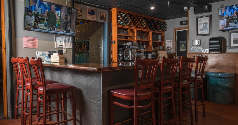 Interior, bar area, wooden top bar with wooden stools, large wooden drink shelf