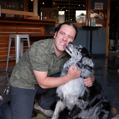 Person hugging a dog inside a brewery.