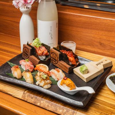Sushi and nigiri, served on a black rectangular plate and a wooden board.